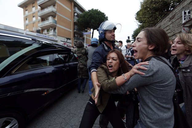 Anti-fascist demonstrators shout as the hearse carrying the coffin of Nazi war criminal Erich Priebke arrives in Albano Laziale, near Rome, on Tuesday. A Catholic splinter group planned to hold a funeral for Priebke, despite attempts by the local mayor to prevent it. (Image credit: Reuters /Landov)