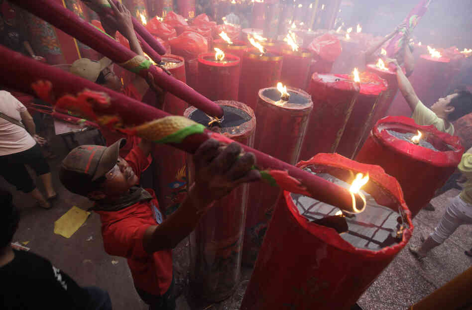 A worker burns large incense sticks during the celebration of the Lunar New Year of the Tiger at a temple in the Chinatown in Jakarta, Indonesia, on Feb. 14, 2010. A worker burns large incense sticks during the celebration of the Lunar New Year of the Tiger at a temple in the Chinatown in Jakarta, Indonesia, on Feb. 14, 2010.