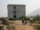 Relatives of He Mengqing walk in front of his house, which the local government has slated for demolition. The rice farmer from Chenzhou in China's Hunan province rejected a government offer of compensation for his land; he set himself on fire when officials came for him. Relatives of He Mengqing walk in front of his house, which the local government has slated for demolition. The rice farmer from Chenzhou in China's Hunan province rejected a government offer of compensation for his land; he set himself on fire when officials came for him.
