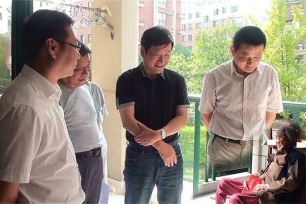 In a photo originally posted to a county government website, local officials purportedly visit a 100-year-old woman in Anhui province. They sure are tall, aren't they? And what happened to the legs of the guy on the right?
