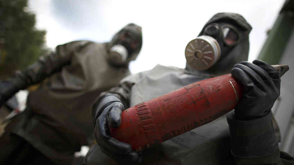 Workers in protective suits hold dummy munition during a demonstration at a chemical weapons disposal facility in Muenster, Germany, on Wednesday. Workers in protective suits hold dummy munition during a demonstration at a chemical weapons disposal facility in Muenster, Germany, on Wednesday.
