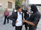 A Syrian fighter from the Islamist rebel group Jabhat al-Nusra inspects a resident's identification papers at a checkpoint in Aleppo on Oct. 26. Syria's Islamist fighters are generally better funded than their more moderate counterparts. A Syrian fighter from the Islamist rebel group Jabhat al-Nusra inspects a resident's identification papers at a checkpoint in Aleppo on Oct. 26. Syria's Islamist fighters are generally better funded than their more moderate counterparts.