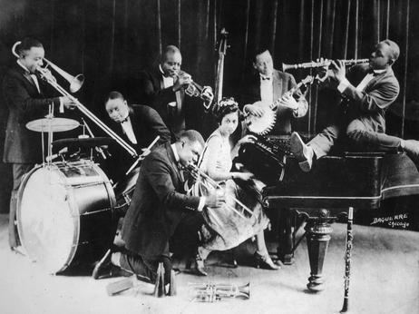 King Oliver's Creole Jazz Band in Chicago in 1923: Louis Armstrong is kneeling, from left to right behind him are Honore Dutrey, Baby Dodds, King Oliver, Lil Hardin, Bill Johnson and Johnny Dodds. King Oliver's Creole Jazz Band in Chicago in 1923: Louis Armstrong is kneeling, from left to right behind him are Honore Dutrey, Baby Dodds, King Oliver, Lil Hardin, Bill Johnson and Johnny Dodds.