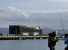 Two men fish in the water in front of a barge on Treasure Island in San Francisco on Tuesday. An unnamed source tells CBS the barge carries a building "constructed of interchangeable 40-foot shipping containers that can be assembled and disassembled at will, allowing it to be placed on barges, trucks or rail cars and taken anywhere in the world." Two men fish in the water in front of a barge on Treasure Island in San Francisco on Tuesday. An unnamed source tells CBS the barge carries a building "constructed of interchangeable 40-foot shipping containers that can be assembled and disassembled at will, allowing it to be placed on barges, trucks or rail cars and taken anywhere in the world."