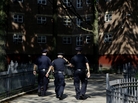 New York police officers walk through a Brooklyn housing development in August. New York police officers walk through a Brooklyn housing development in August.