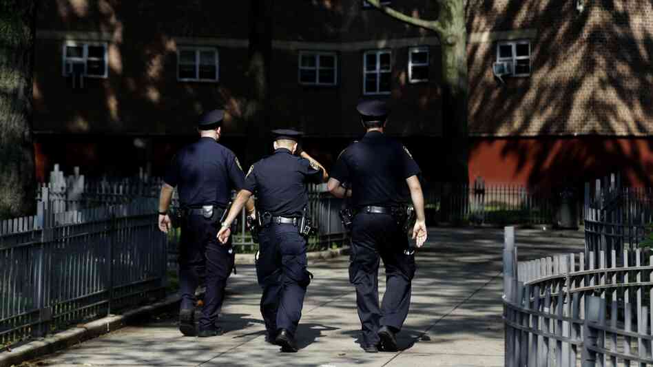 New York police officers walk through a Brooklyn housing development in August. New York police officers walk through a Brooklyn housing development in August.