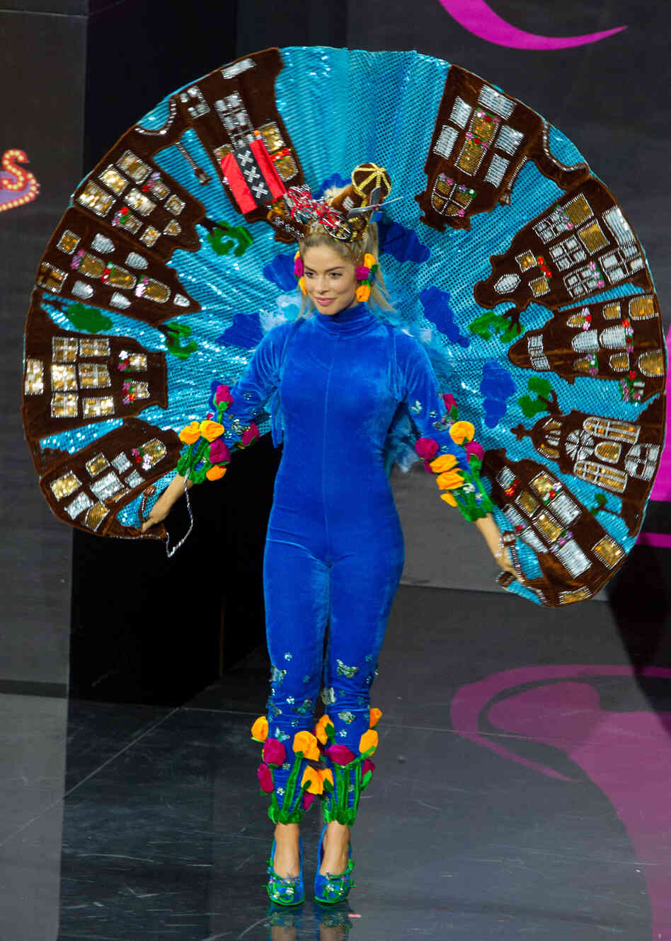 I just want you to pause and appreciate that she is wearing what appears to be a velvet jumpsuit with a standing Elvis cape made of buildings, a windmill and a bicycle on her head, and tulips on her pants. (Miss Netherlands: Stephanie Tency)