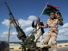 Militias from towns throughout the country's west parade through Tripoli, Libya, in 2012. Analysts say the country is awash with heavy weapons in the hands of militias divided by tribe, ideology and region. The central government has little power over the gunmen. Militias from towns throughout the country's west parade through Tripoli, Libya, in 2012. Analysts say the country is awash with heavy weapons in the hands of militias divided by tribe, ideology and region. The central government has little power over the gunmen.