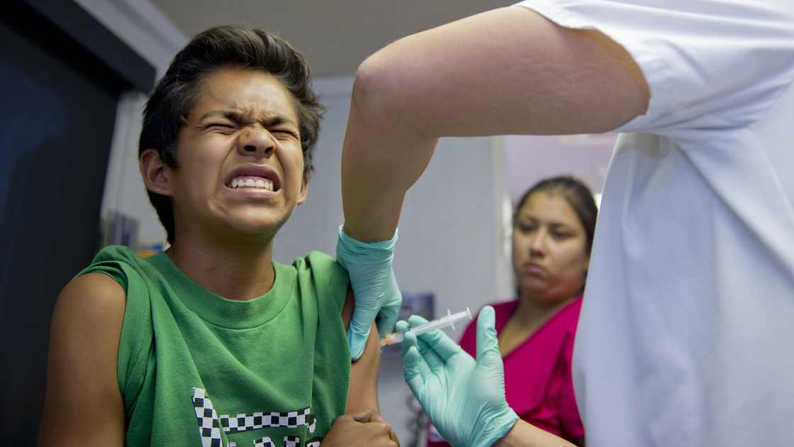 Public school student Julio Valenzuela, 11, grimaces as he gets a vaccination before the start of the school in Lynnwood, Calif., on Aug. 27. Vaccines are required for school attendance.