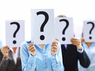 A group of people holding up question marks in front of their faces. A group of people holding up question marks in front of their faces.