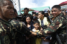 Soldiers hold back people who are waiting to board a military aircraft in Tacloban. While the government, international aid groups and foreign militaries have rushed to the affected area, they are having trouble getting to the victims because of blocked roads, the U.S. commander on the scene told NPR early Wednesday. Soldiers hold back people who are waiting to board a military aircraft in Tacloban. While the government, international aid groups and foreign militaries have rushed to the affected area, they are having trouble getting to the victims because of blocked roads, the U.S. commander on the scene told NPR early Wednesday.