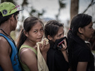 In Tacloban, the Philippines, on Thursday, some survivors waiting in a line to charge cellphones covered their faces because of the lingering smell of dead bodies. In Tacloban, the Philippines, on Thursday, some survivors waiting in a line to charge cellphones covered their faces because of the lingering smell of dead bodies.