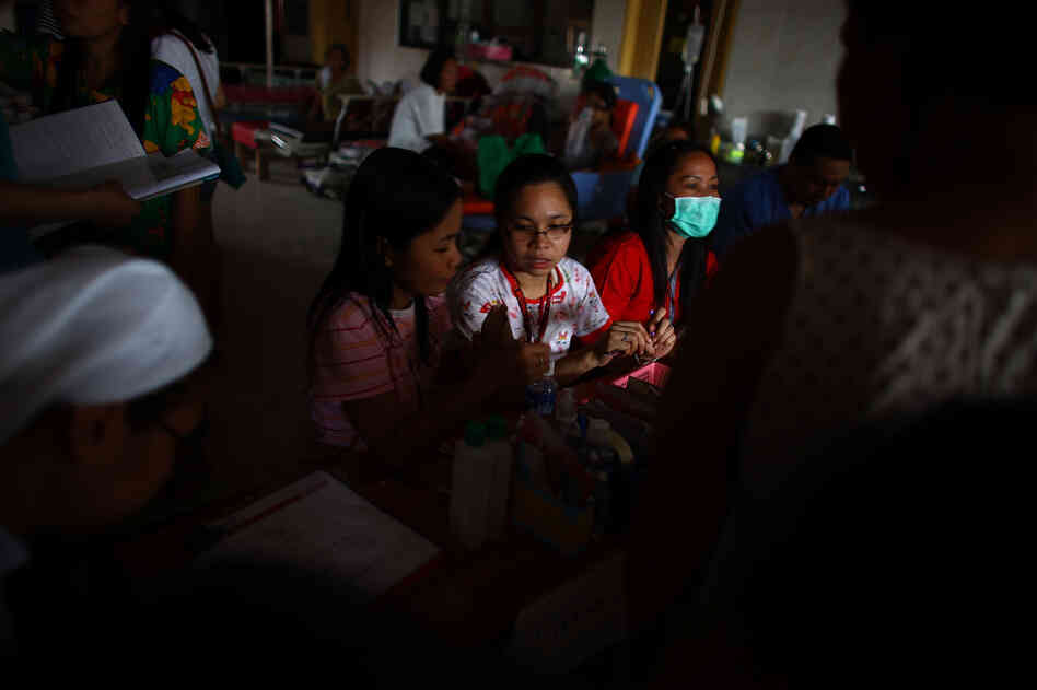 Nurses at Divine Word Hospital in Tacloban, Philippines, do their best to organize a list of patients seeking medical attention. Nurses at Divine Word Hospital in Tacloban, Philippines, do their best to organize a list of patients seeking medical attention.