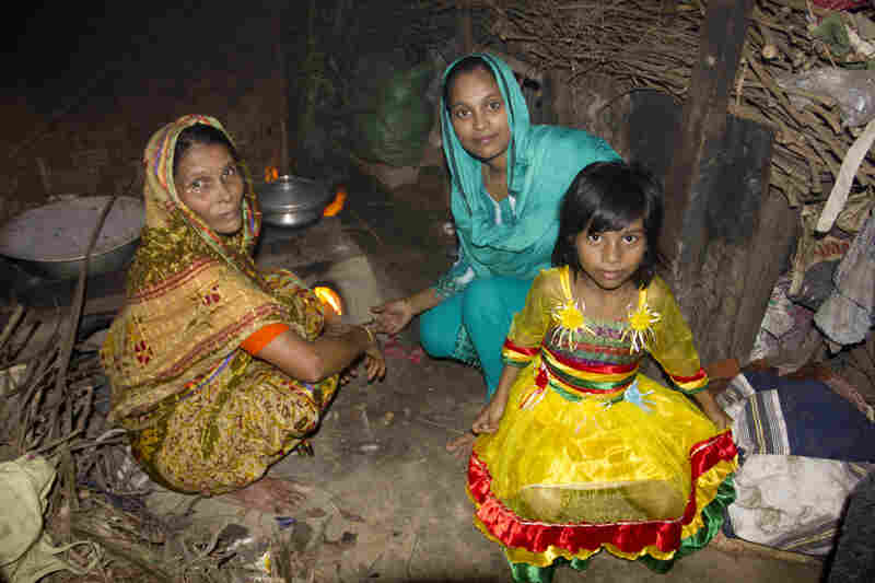 Minu's mother, Noor Jahan Begum (left), sits near the family stove with Minu and Sumaiya. Sumaiya lives here with Minu's parents. 