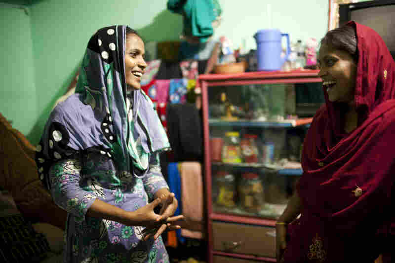 Shumi (left) and Minu inside the small room they share with Minu's husband in Chittagong.