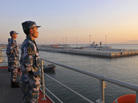 Chinese naval soldiers stand guard on China's first aircraft carrier Liaoning as it travels toward a military base in Sanya, Hainan province, in this undated picture made available on Nov. 30. Chinese naval soldiers stand guard on China's first aircraft carrier Liaoning as it travels toward a military base in Sanya, Hainan province, in this undated picture made available on Nov. 30.