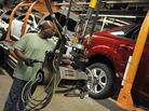 An auto worker tightens bolts on the wheel of a Focus at a Ford plant in Wayne, Mich. Reports this week showed increases in auto sales and manufacturing jobs. An auto worker tightens bolts on the wheel of a Focus at a Ford plant in Wayne, Mich. Reports this week showed increases in auto sales and manufacturing jobs.