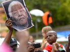 A man holds a portrait of Nelson Mandela outside his home in Houghton, Johannesburg, on Sunday. A man holds a portrait of Nelson Mandela outside his home in Houghton, Johannesburg, on Sunday.