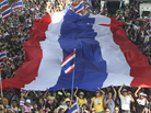 Anti-government protesters carry a Thai national flag as they march Monday in Bangkok. Anti-government protesters carry a Thai national flag as they march Monday in Bangkok.