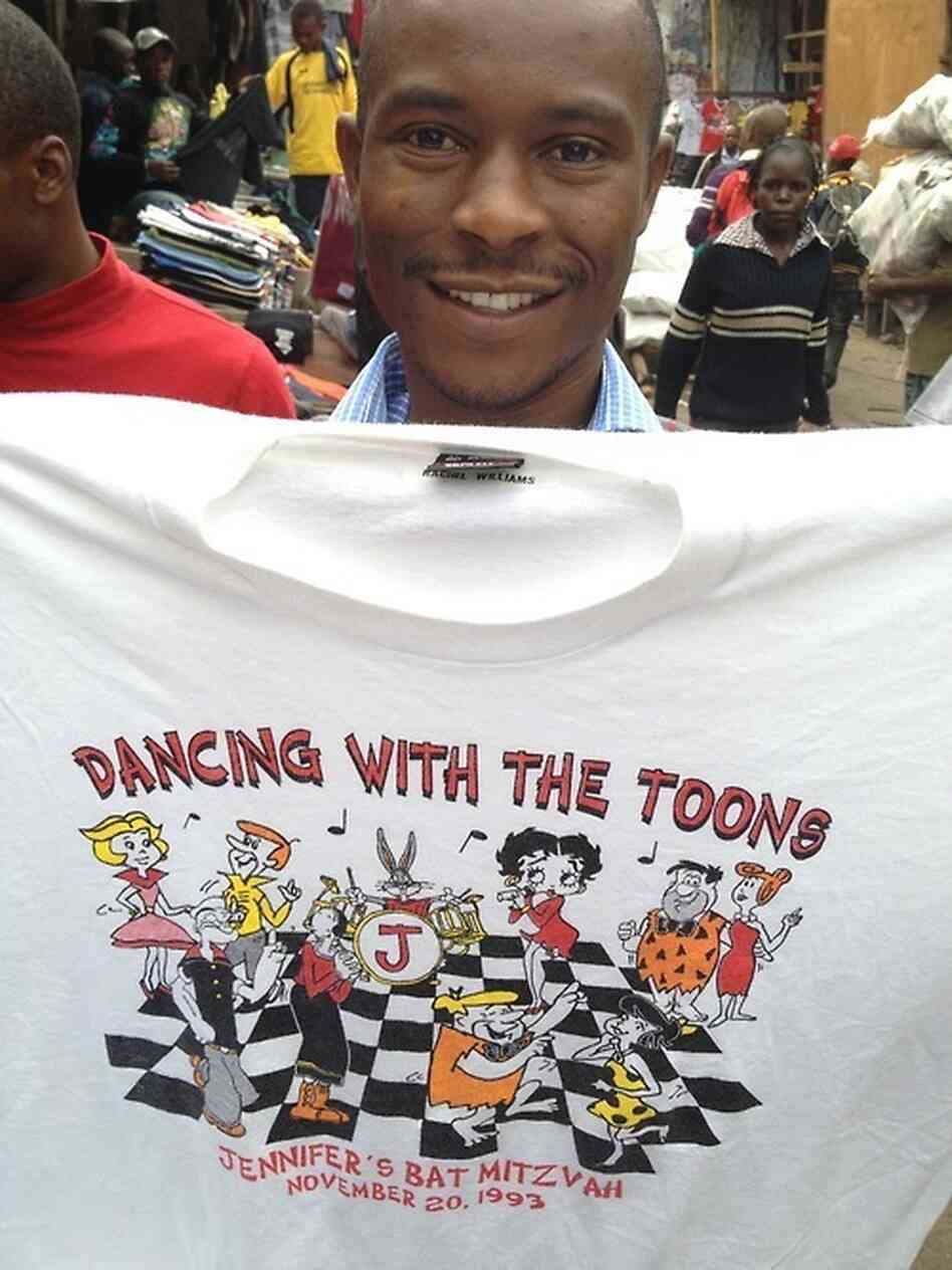 Paul Warambo holds up a used T-shirt for sale in Nairobi, Kenya. With the help of the internet, we found the original owner Paul Warambo holds up a used T-shirt for sale in Nairobi, Kenya. With the help of the internet, we found the original owner