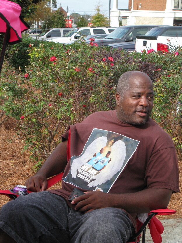 Kenneth Johnson wears a shirt with an image of his son Kendrick, 17, in November. Johnson and other family members have maintained a presence near the Lowndes County judicial complex in Valdosta, Ga., since last January after Kendrick's body was discovered in a gym mat at his high school. (Image credit: NPR)