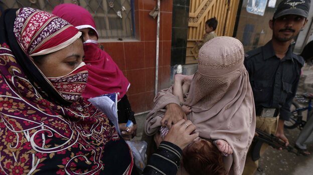 A polio worker administers polio vaccine to a child in Khyber-Pakhtunkhwa province, Pakistan, in October. (Image credit: EPA/Landov)