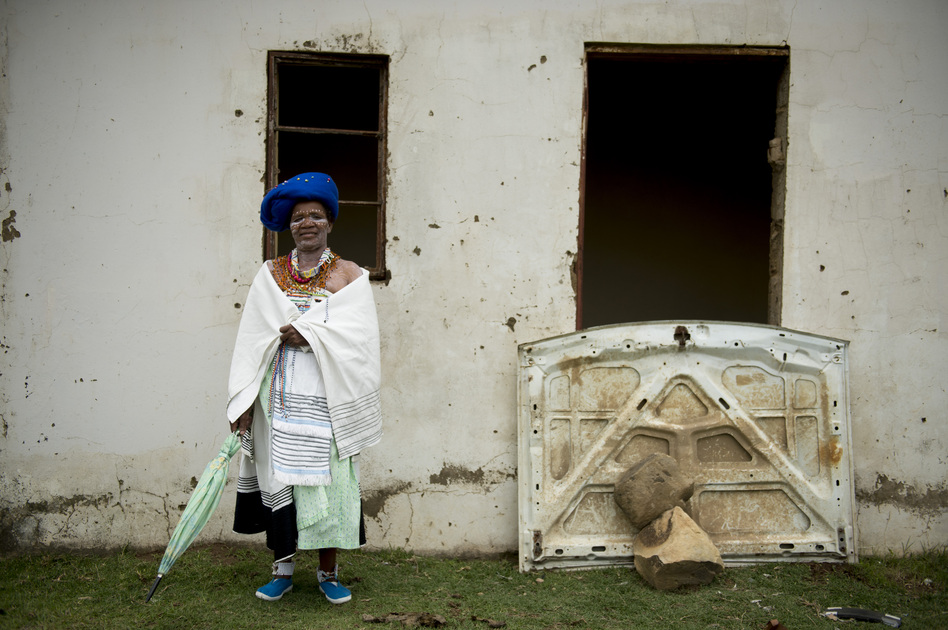 A woman in traditional clothes and face paint stands along the road awaiting the home coming of Mandela's remains in Qunu on Saturday.