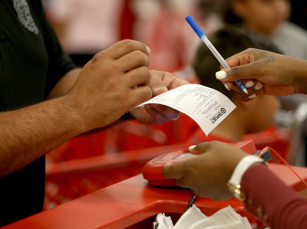 A customer prepares to sign a credit card slip Thursday at a Target store in Miami. The giant retailer says 40 million payment cards nationwide may have been compromised by data theft. (Image credit: Getty Images)