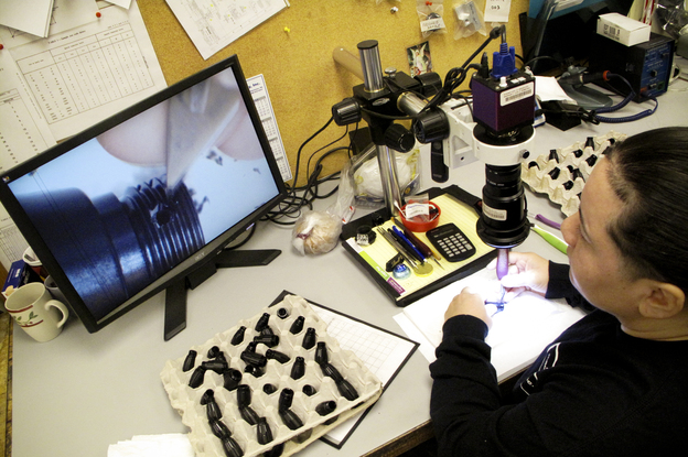 Evelis Pacheco lost her job when a cardboard box manufacturer shut down. Now she says she's learning new skills and doing more interesting work at Machine Inc., making components for heart pumps used in surgery. (Image credit: NPR)