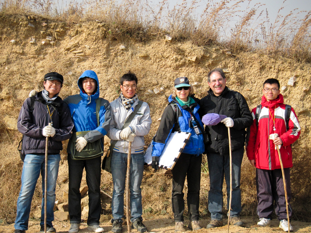 Behind archaeologists Gary Feinman, Linda Nicholas and their crew of graduate student researchers, a cut-away portion of the Qi wall reveals its rammed-earth construction. (Image credit: Courtesy of Gary Feinman/The Field Museum)