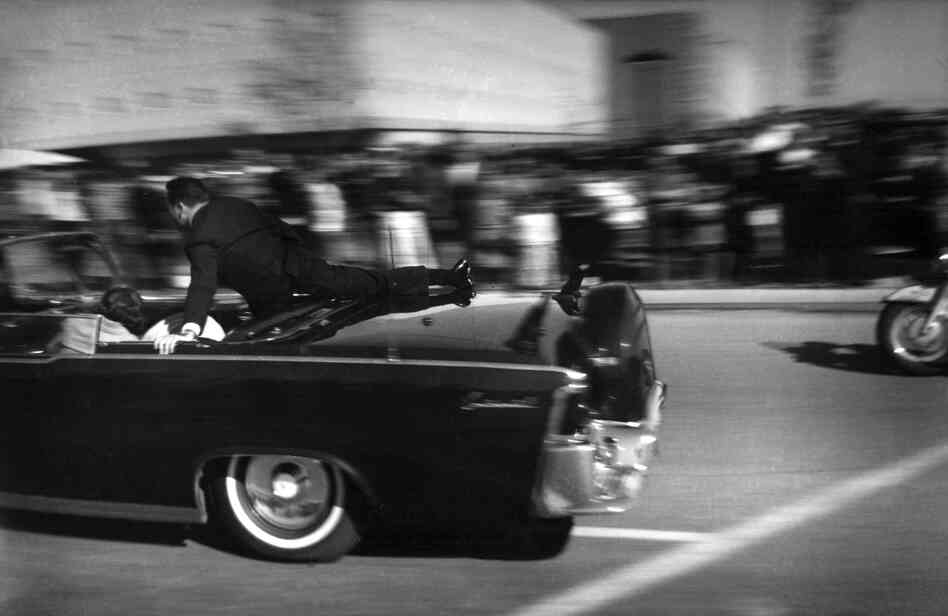 The limousine carrying mortally-wounded President John F. Kennedy races toward Parkland Hospital in Dallas just seconds after he was shot. The limousine carrying mortally-wounded President John F. Kennedy races toward Parkland Hospital in Dallas just seconds after he was shot.