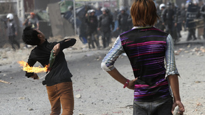 A worker throws a petrol bomb after clashes broke out during a protest Friday near Phnom Penh, Cambodia. At least four people were killed when police opened fire at the workers.
