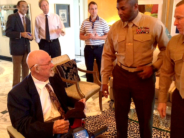Hal Faulkner (left), 79, receives his new papers from two Marines after having his military status changed to 'honorable discharge' at a recent ceremony. Faulkner was kicked out of the Marine Corps in 1956 for being gay. (Image credit: Courtesy of Phil Latzman)