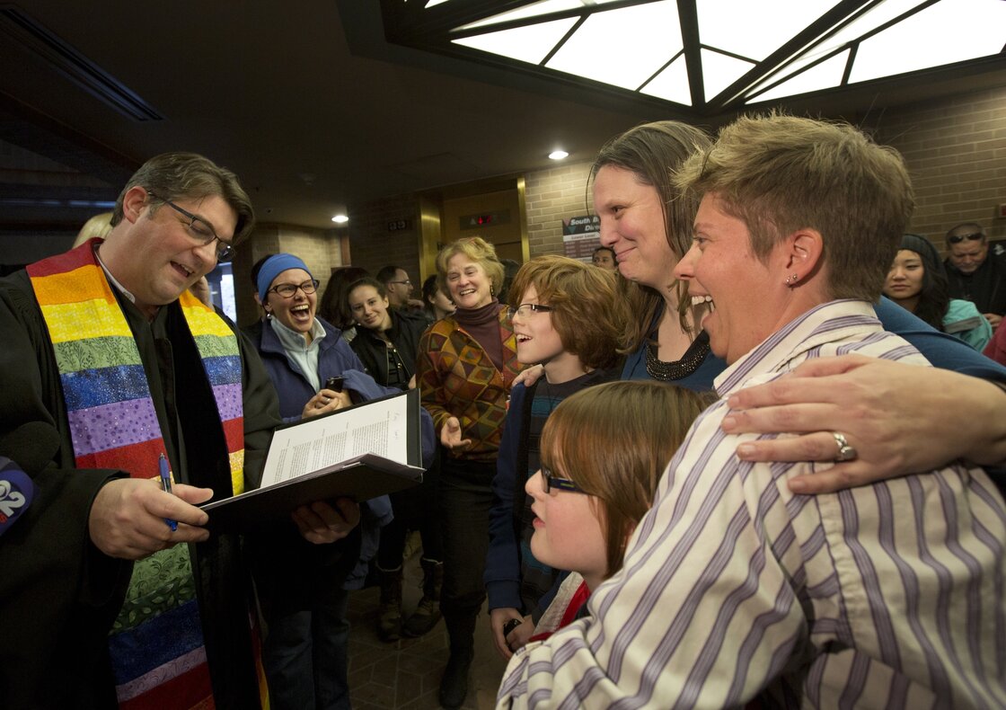 Ruth Hackford-Peer, right, and Kim Hackford-Peer are married by Rev. Curtis Price, while hugging their two children in the lobby of the Salt Lake County Clerk's Office on Dec. 20.