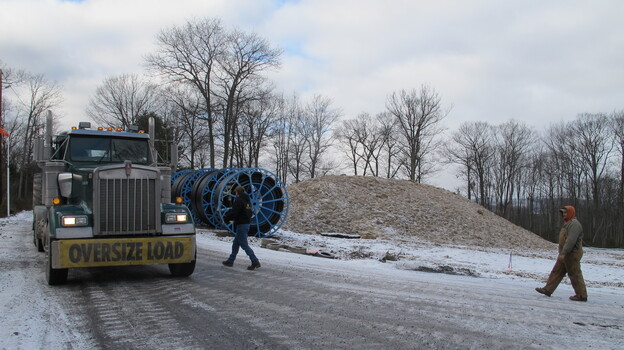 An oversized truck load slowly moves equipment along an icy mountain road in Pennsylvania's Tiadaghton State Forest. (Image credit: WITF)