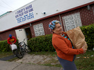 Elba Salsado walks with her groceries after receiving them from a food bank in Miami. Elba Salsado walks with her groceries after receiving them from a food bank in Miami.