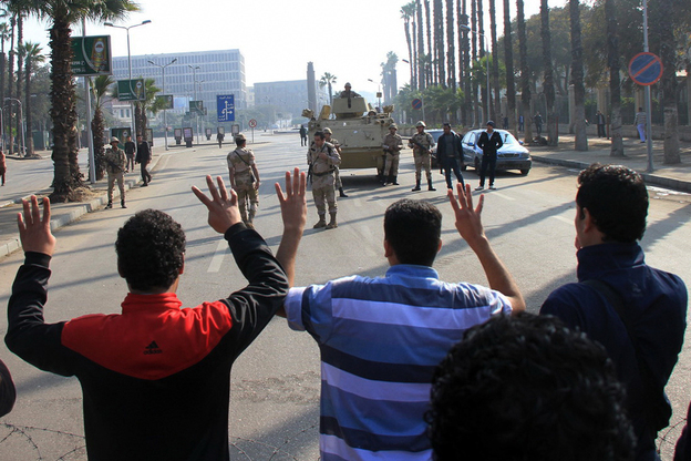 Cairo University students, who are supporters of the Muslim Brotherhood and deposed Egyptian President Mohamed Morsi, protest in front of security forces in Cairo on Jan. 10. The government has outlawed Morsi's political party and declared it a terrorist group. (Image credit: APA /Landov)