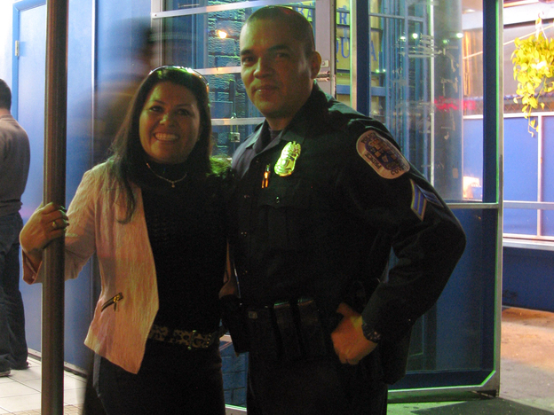 Prince George's County, Md., Police Officer Juan Damian and Dora Escobar outside one of her popular check cashing businesses. (Image credit: NPR)