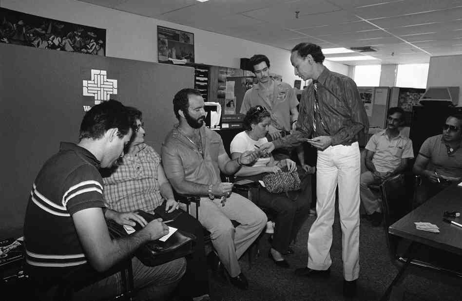 Cuban immigrants are handed forms to fill out by an immigration and naturalization official in Miami on Dec. 3, 1984, so they can become permanent residents of the United States. Cuban immigrants are handed forms to fill out by an immigration and naturalization official in Miami on Dec. 3, 1984, so they can become permanent residents of the United States.