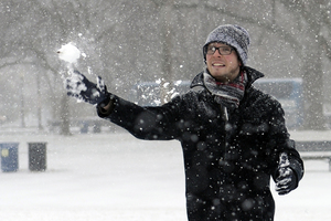 Rick Mendenhall of Albuquerque, N.M., throws a snowball during a snowball fight with friends on the National Mall in Washington, D.C. Thousands of flights were canceled, students got an extra day off from school, and the federal government closed its offices in the Washington area Tuesday.