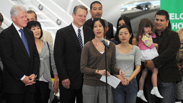 Freed U.S. journalist Laura Ling (center) speaks after she and fellow journalist and Euna Lee (3rd from right) arrive in Burbank, Calif., from North Korea on Aug. 5, 2009. After talks in Pyongyang with former U.S. President Bill Clinton (left), then-North Korean leader Kim Jong Il pardoned the women, who were sentenced to hard labor for entering the country illegally. (Image credit: AFP/Getty Images)