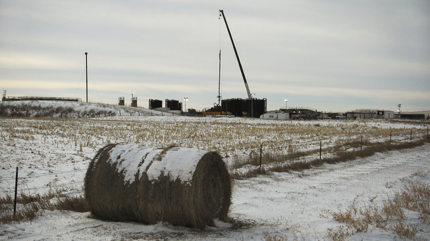 A drilling site rises from the middle of farmland near Fairfield, N.D. Many farmers and ranchers are profiting from the state's oil boom, but others complain that drillers are interfering with their business. (Image credit: NPR)