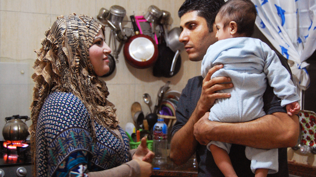 Ala'a Miqbel (shown here with his wife and their youngest son in their Gaza City apartment) was held for nearly four weeks in an Israeli prison, then released without charges. There, he met the 'sparrows' — Palestinians who appear to be fellow prisoners but are actually gathering information for the Israelis. (Image credit: NPR)