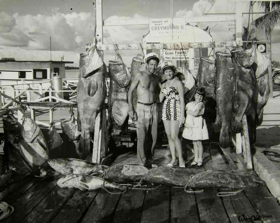 A proud fishing family in 1958 stands before several prizewinning fish much bigger than a human 5-year-old. A proud fishing family in 1958 stands before several prizewinning fish much bigger than a human 5-year-old.