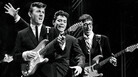 The Shadows on stage in the 1960s. The British rock act, formed as a backing band for singer Cliff Richard (center), was among the U.K. acts who stayed behind as The Beatles and others were cresting in America. The Shadows on stage in the 1960s. The British rock act, formed as a backing band for singer Cliff Richard (center), was among the U.K. acts who stayed behind as The Beatles and others were cresting in America.