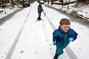Milo Kortemeier runs away from John Staton after pelting him with a snowball in Decatur, Ga. Icy road conditions caused some businesses and schools to shut down in the greater metro Atlanta region.