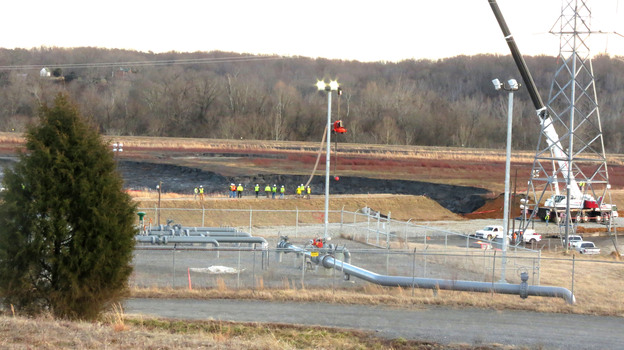 Duke Energy crews work to repair the broken coal ash pond. Coal ash is a byproduct of the coal burned to produce electricity. (Image credit: Ben Bradford for NPR)