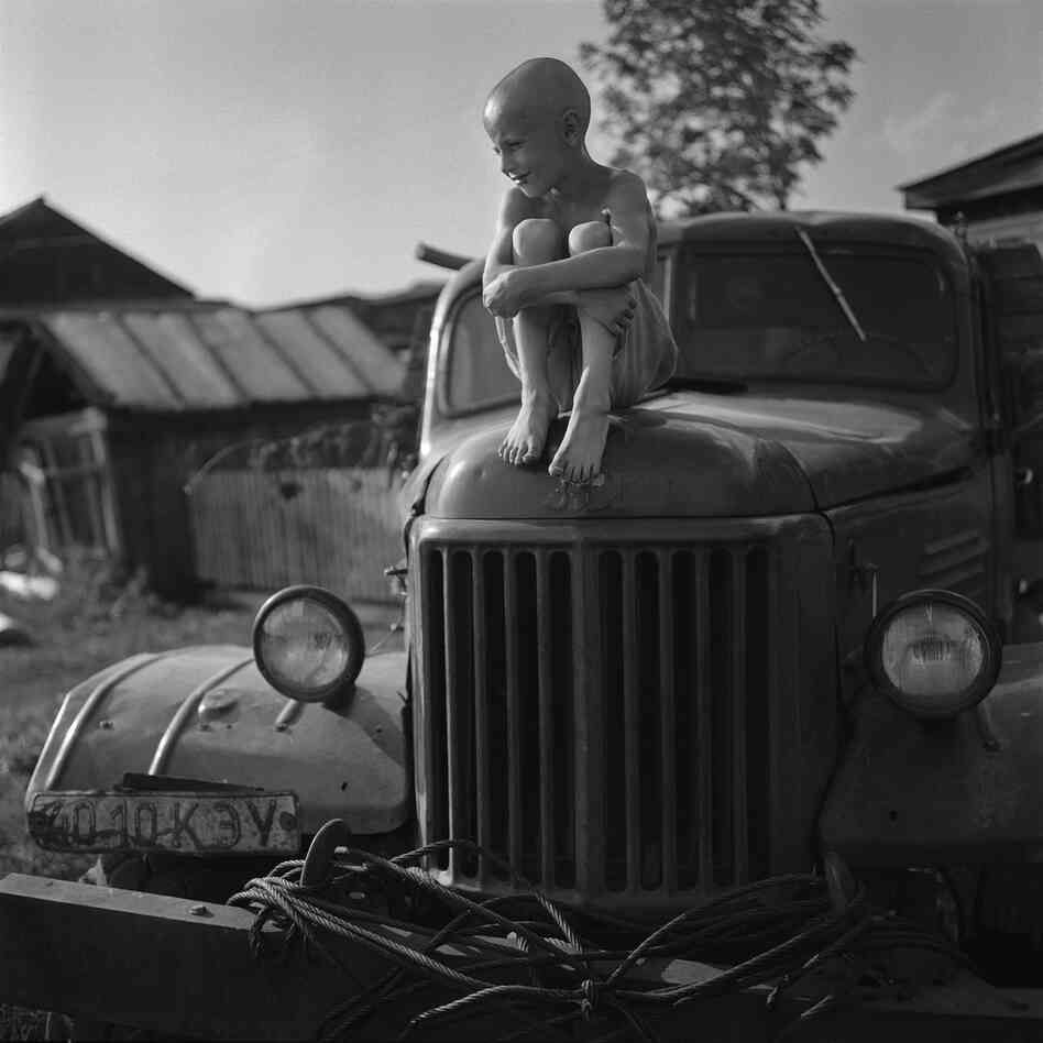 A boy named Zahar sits on an old car in a village called Rossiyka near Krasnoyarsk. A boy named Zahar sits on an old car in a village called Rossiyka near Krasnoyarsk.