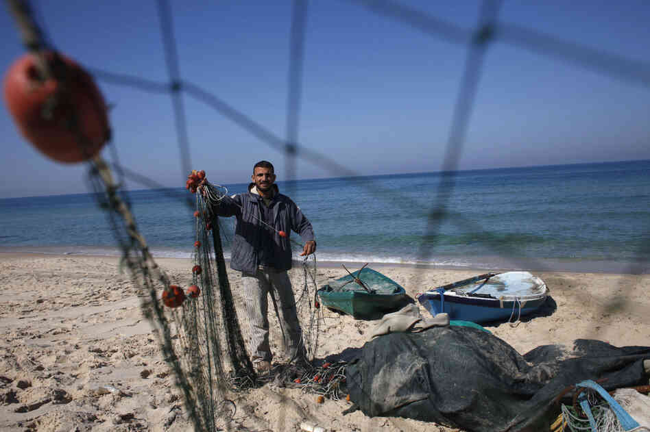 Palestinian fisherman Judah Abughorab, who said he pulled the bronze Apollo statue from the seabed last August, prepares his fishing net on the beach of Deir El-Balah in the central Gaza Strip on Feb. 9. Palestinian fisherman Judah Abughorab, who said he pulled the bronze Apollo statue from the seabed last August, prepares his fishing net on the beach of Deir El-Balah in the central Gaza Strip on Feb. 9.