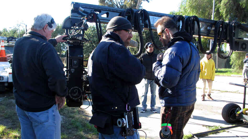 On location for Walk of Shame, camera crew members Larry Nielsen (center) and Milan "Miki" Janicin (right) help set up a crane shot. The wireless focus remote Nielsen will use is hanging from that purple carabiner on his jacket. On location for Walk of Shame, camera crew members Larry Nielsen (center) and Milan "Miki" Janicin (right) help set up a crane shot. The wireless focus remote Nielsen will use is hanging from that purple carabiner on his jacket.